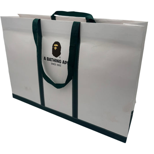 White tote bag with green handles featuring a logo on a white background