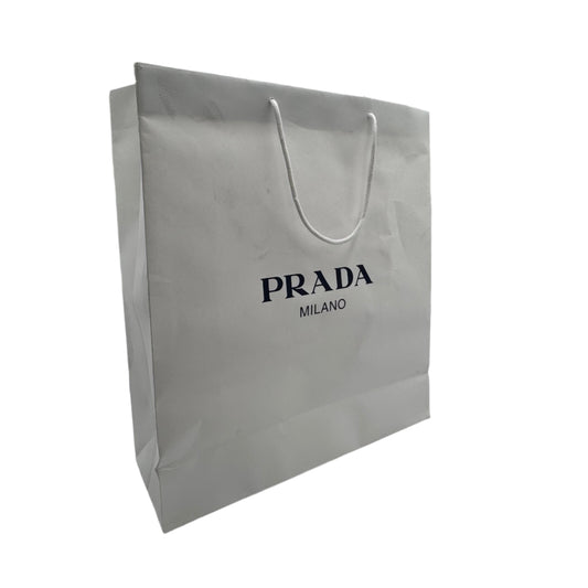White Prada shopping bag in a reflective indoor setting