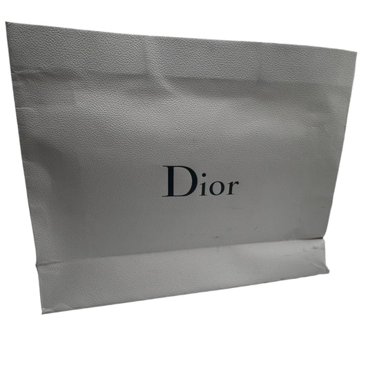 Dior shopping bag in a white room with reflective walls