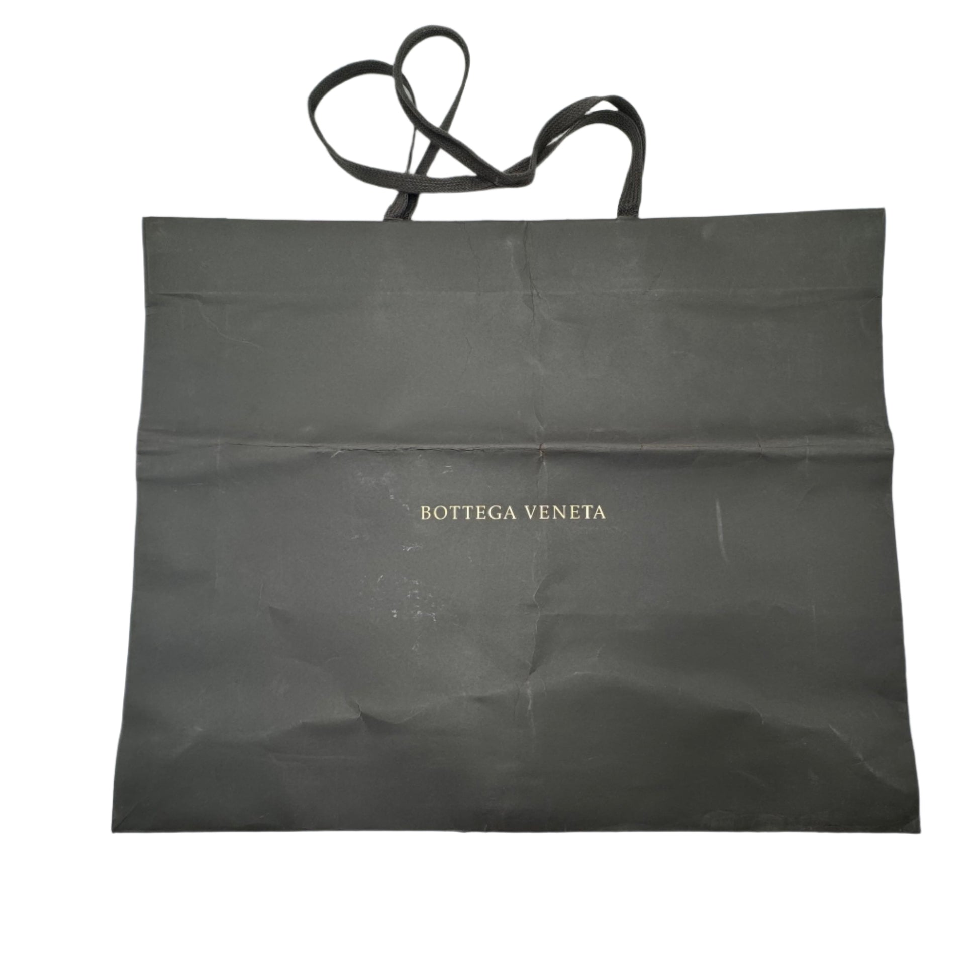 Black bag with 'Bottega Veneta' branding on a white surface
