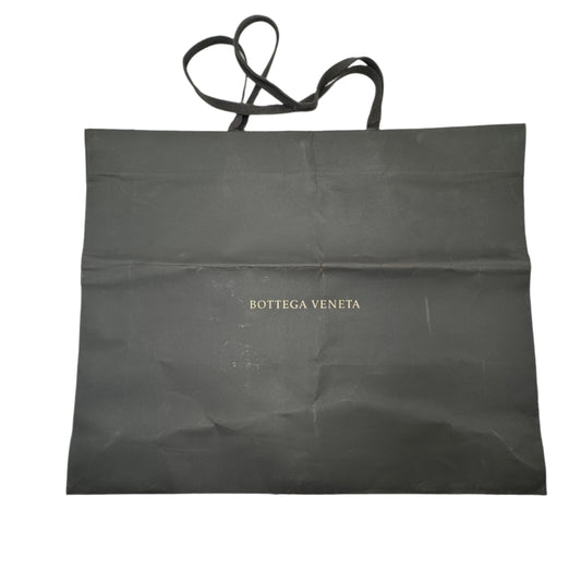 Black bag with 'Bottega Veneta' branding on a white surface