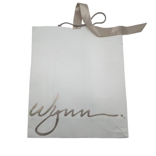 White card with 'Wynn' written on it, attached to a white wall with a ribbon.