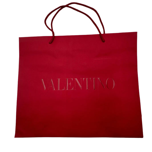Red shopping bag with 'Valentino' branding on a white background